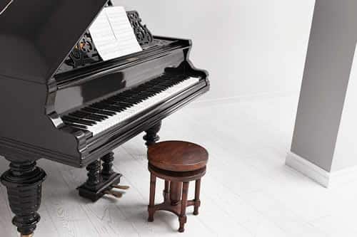 Piano removals in Edinburgh with specialist movers transporting an upright piano using protective covers and careful handling